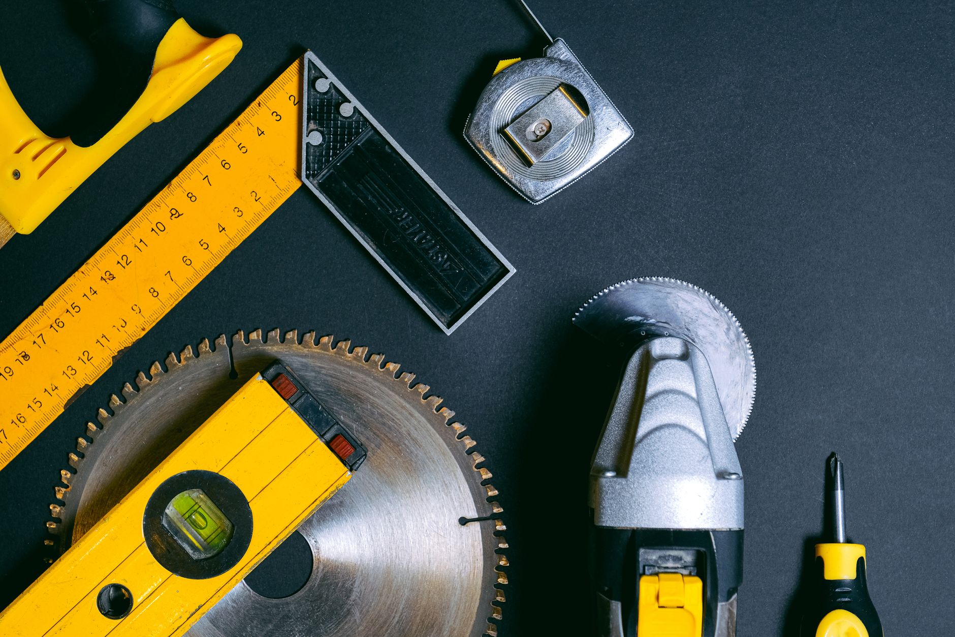 A neatly arranged collection of essential home repair tools on a wooden workbench
